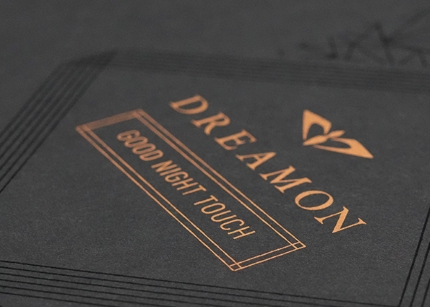 Copper-gold ink creates premium shine on dark box surface.