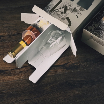 Elegant gift box with SAULĖS MIDUS mead bottle and glass. Window panels allow visibility of the engraved logo and label.